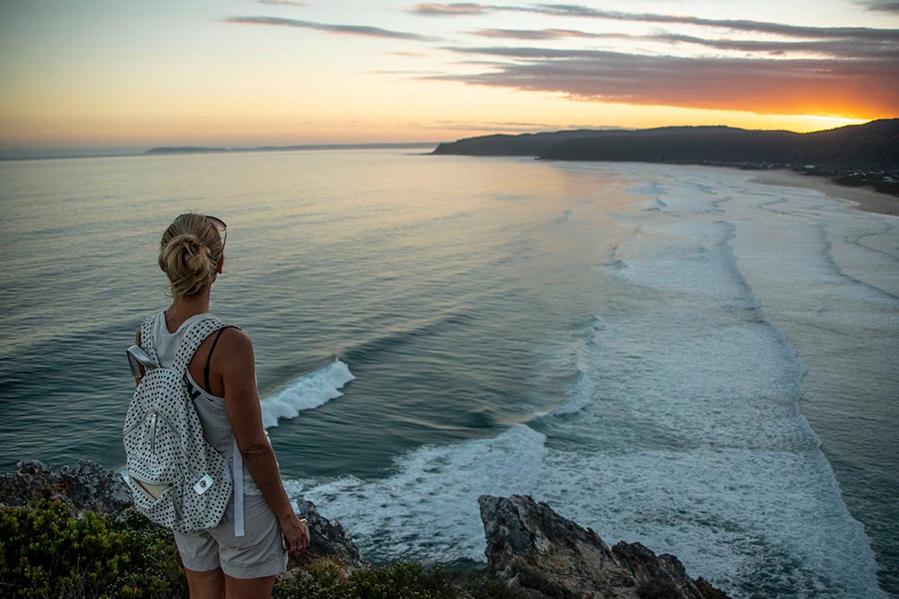 Person looking at ocean view at sunset in Natures Valley in South Africa