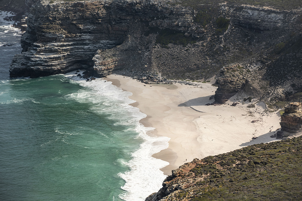 Distant beach surrounded by cliffs