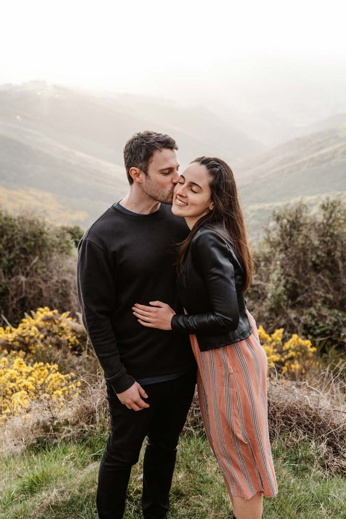 Couple standing on hills at sunset