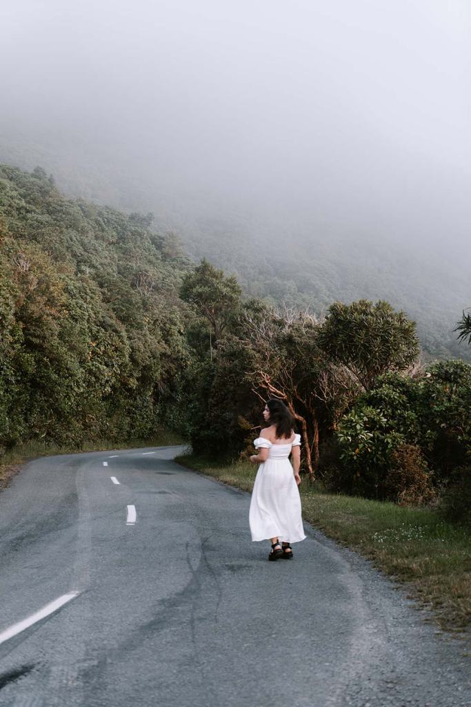 Woman on road with mist and trees