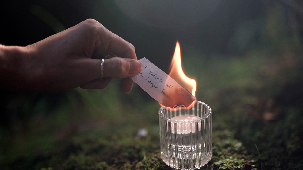 Burning note with candle flame